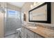 Bathroom featuring a vanity with granite countertop, framed mirror, and glass shower at 1107 Almond Tree Cir, Orlando, FL 32835