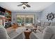 Bright living room with ceiling fan, tile fireplace and view of backyard pool at 1107 Almond Tree Cir, Orlando, FL 32835
