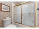 Clean bathroom with a white toilet, tiled walls, and a bathtub with a gold-framed glass door at 1146 Villa Ln # 101, Apopka, FL 32712