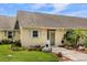 Charming yellow home with well-manicured lawn, garden beds, and white shutters offers a welcoming entrance at 1146 Villa Ln # 101, Apopka, FL 32712