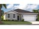 Charming single-Gathering home with gray stucco, a two-car garage, and a well-manicured lawn at 1267 Normandy Dr, Haines City, FL 33844
