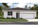 Charming single-story home featuring a stucco facade, well-manicured lawn, and attached one-car garage at 1323 Normandy Dr, Haines City, FL 33844