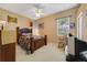 Bedroom with carpet, a bed, side table, and window providing natural light, and a ceiling fan for comfort at 1515 Cherry Lake Way, Lake Mary, FL 32746