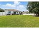 Expansive backyard featuring a well-manicured lawn and a view of the home's patio at 15411 Taurus Ct, Mascotte, FL 34753