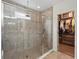 Bathroom shower with glass door and tile surround at 15411 Taurus Ct, Mascotte, FL 34753