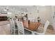 Open-concept dining room featuring a wooden table and six white chairs at 15411 Taurus Ct, Mascotte, FL 34753