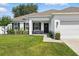 Close up shot of a charming one story home with manicured front lawn at 15411 Taurus Ct, Mascotte, FL 34753