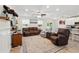 Bright living room features neutral colors, large windows and comfortable seating at 15411 Taurus Ct, Mascotte, FL 34753