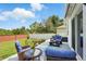 Inviting outdoor patio with blue furniture, potted flowers, and well-maintained backyard at 15411 Taurus Ct, Mascotte, FL 34753