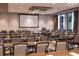 Large conference room set up with rows of tables and chairs, a projector screen, and bottled water for attendees at 15695 Grove Resort Ave # 4308, Winter Garden, FL 34787