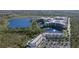 Expansive aerial view of a modern resort complex nestled beside a lake, surrounded by lush greenery and trees at 15695 Grove Resort Ave # 4412, Winter Garden, FL 34787