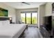Bright hotel bedroom with a large window showcasing a beautiful green tree view, a king bed and television at 15695 Grove Resort Ave # 4412, Winter Garden, FL 34787