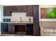 Well-equipped kitchenette featuring sleek cabinetry, modern appliances, and a comfortable seating area with vibrant artwork at 15695 Grove Resort Ave # 4412, Winter Garden, FL 34787
