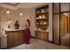 Warmly lit spa reception area with a friendly receptionist assisting a guest near display shelves with products at 15695 Grove Resort Ave # 4412, Winter Garden, FL 34787