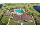 An aerial view of a clubhouse with multiple pools, palm trees, and lounge chairs surrounded by a manicured lawn at 15946 Marina Bay Dr, Winter Garden, FL 34787