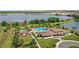 Aerial view of a clubhouse, featuring swimming pools, a bath house, lush landscaping and a lake in the background at 15946 Marina Bay Dr, Winter Garden, FL 34787
