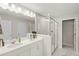 Bright bathroom with dual sinks, large mirror, and glass-enclosed shower offering a spa-like experience at 15946 Marina Bay Dr, Winter Garden, FL 34787