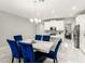 Open dining area showcasing a marble table, blue velvet chairs, and a view of the modern kitchen at 15946 Marina Bay Dr, Winter Garden, FL 34787