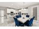 Dining room with blue velvet chairs, a marble-top table, and an open view to the kitchen at 15946 Marina Bay Dr, Winter Garden, FL 34787