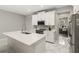 Open kitchen with an island, white cabinetry, stainless steel appliances, and adjacent office space at 15946 Marina Bay Dr, Winter Garden, FL 34787