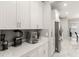 Kitchenette with white cabinets, quartz countertops, stainless steel refrigerator and marble tile flooring at 15946 Marina Bay Dr, Winter Garden, FL 34787