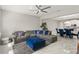 Open-concept living room with a gray sectional, ottoman, and view into the adjacent dining and kitchen areas at 15946 Marina Bay Dr, Winter Garden, FL 34787