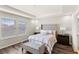 Bright main bedroom featuring a comfortable bed, tray ceiling, and a view of the neighborhood at 15946 Marina Bay Dr, Winter Garden, FL 34787