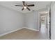Neutral toned bedroom with ceiling fan, tile floors, and an open doorway to the hall at 160 Conch Dr, Kissimmee, FL 34759