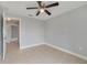 A spacious bedroom featuring a ceiling fan and neutral color scheme with access to hallway at 160 Conch Dr, Kissimmee, FL 34759