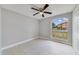 A well lit bedroom with a ceiling fan and a large window with a view of the neighborhood at 160 Conch Dr, Kissimmee, FL 34759