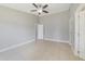 Neutral bedroom with tile floors, ceiling fan and white doors at 160 Conch Dr, Kissimmee, FL 34759