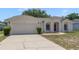 Charming single-story home featuring a two-car garage, manicured lawn, and a welcoming red front door at 160 Conch Dr, Kissimmee, FL 34759