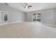 Spacious living room featuring neutral paint, ceiling fan and tile flooring with backyard views at 160 Conch Dr, Kissimmee, FL 34759