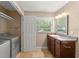 A bright bathroom featuring a modern vanity, lighting, and a window for natural light with laundry machine at 17 S Aurora Dr, Apopka, FL 32703