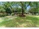 Charming front exterior featuring mature trees, green lawn, and an inviting red door at 17 S Aurora Dr, Apopka, FL 32703