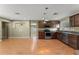 Bright kitchen area with stainless appliances, wood cabinetry and recessed lighting, adjacent to the living room at 17 S Aurora Dr, Apopka, FL 32703