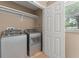 Laundry room features new front loading machines, storage shelving, and natural light from a window at 17 S Aurora Dr, Apopka, FL 32703