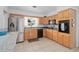 Well-lit kitchen with updated appliances, natural wood cabinets, tiled floors, and a view out the window at 217 Spencer St, Orlando, FL 32839
