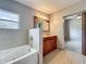 Bathroom featuring a soaking tub and vanity with wood cabinets in neutral tones and natural light at 221 Golden Days Dr, Casselberry, FL 32707