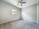 Bedroom features a ceiling fan, neutral carpeting and gray walls and a window at 221 Golden Days Dr, Casselberry, FL 32707