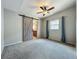 Bedroom features a ceiling fan, gray walls and a decorative barn door to the bathroom at 221 Golden Days Dr, Casselberry, FL 32707