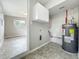 Utility room featuring water heater, overhead cabinets, and easy access to living areas at 221 Golden Days Dr, Casselberry, FL 32707