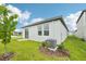 Backyard featuring green lawn, mulch bed, AC unit, sliding glass doors, and bright blue skies at 2502 Linda Knoll Ln, Bartow, FL 33830