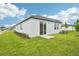 Exterior view of a home showcasing a lush backyard with green grass and sliding glass door access at 2502 Linda Knoll Ln, Bartow, FL 33830