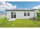 Home backyard featuring a well-maintained lawn, sliding glass door, and modern air conditioning unit at 2502 Linda Knoll Ln, Bartow, FL 33830