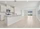 Open-concept kitchen with white cabinets, island, and adjacent living area with sliding glass doors at 2502 Linda Knoll Ln, Bartow, FL 33830