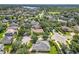 An aerial view of a residential area showcasing well-kept homes, mature trees, and winding streets, with a lake visible in distance at 2528 Double Tree Pl, Oviedo, FL 32766