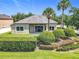 Well-manicured backyard featuring lush lawn, mature landscaping, and a covered patio perfect for outdoor entertaining at 2528 Double Tree Pl, Oviedo, FL 32766