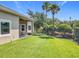 A large backyard is surrounded by green grass and a black metal fence with trees and foliage at 2528 Double Tree Pl, Oviedo, FL 32766