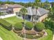 Aerial view of a home's backyard featuring a lush lawn, mature landscaping, and a covered patio at 2528 Double Tree Pl, Oviedo, FL 32766
